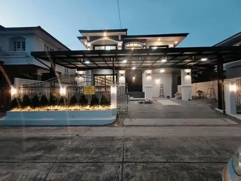Wide view of the house front and carport at dusk
