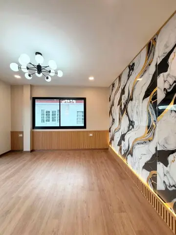 Upstairs room with a black and gold marble-pattern wall and a large window