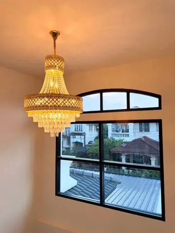 Chandelier and arched window upstairs, with neighbouring roofs in view