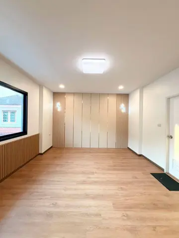 Upstairs room with wood-look floor, slatted wall and a large window